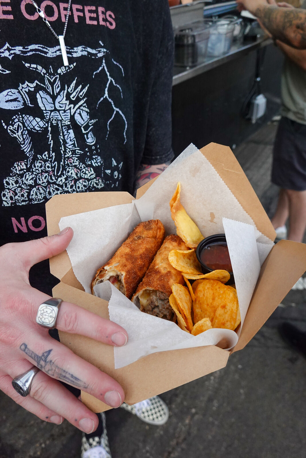 A paper cone of roasted snacks from a market food stand